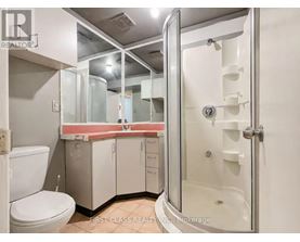 A bathroom with a toilet, sink, and shower.