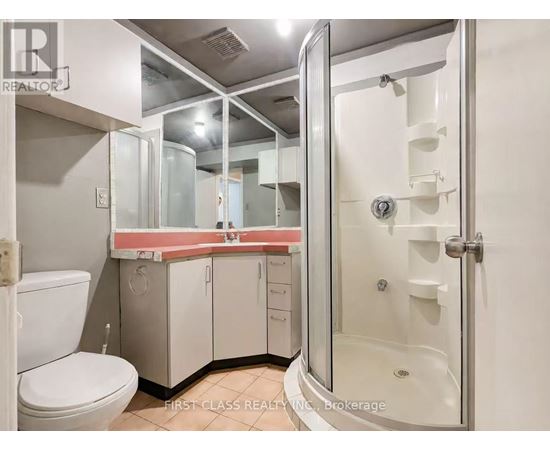 A bathroom with a toilet, sink, and shower.