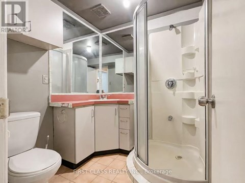 A bathroom with a toilet, sink, and shower.