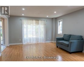 A living room with a couch and a window with curtains.