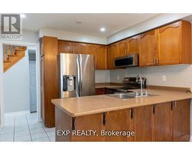 A kitchen with wooden cabinets and a stainless steel refrigerator.