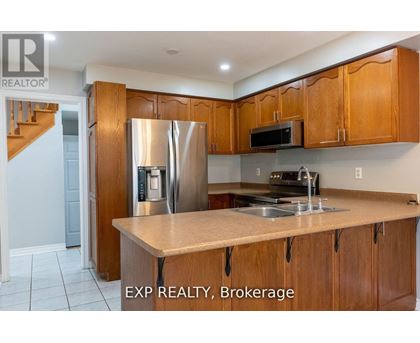 A kitchen with wooden cabinets and a stainless steel refrigerator.