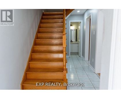 A wooden staircase leads to a hallway with a mirror on the wall.