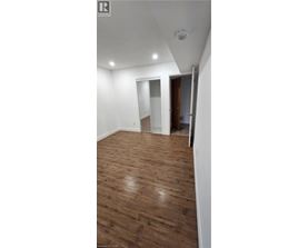 A room with wooden flooring and a white ceiling.
