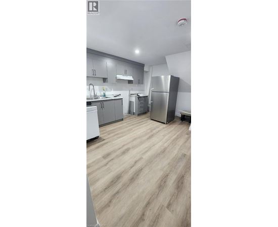 A kitchen with wooden flooring and stainless steel appliances.