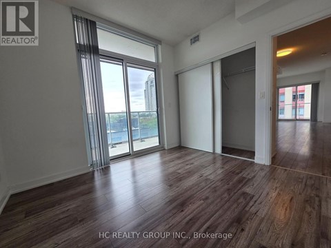 A room with wooden flooring and sliding glass doors.