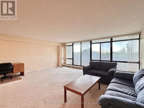 A living room with a grey couch and a wooden coffee table.