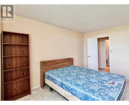 A bedroom with a bed, dresser, and wardrobe.