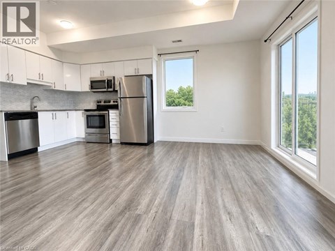 A kitchen with a refrigerator, oven, and microwave.
