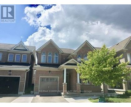 A house with a large front yard and a tree in front of it.