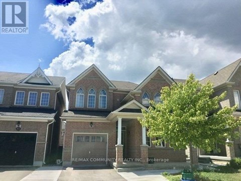 A house with a large front yard and a tree in front of it.