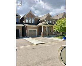 A large house with a brick facade and a large front yard.
