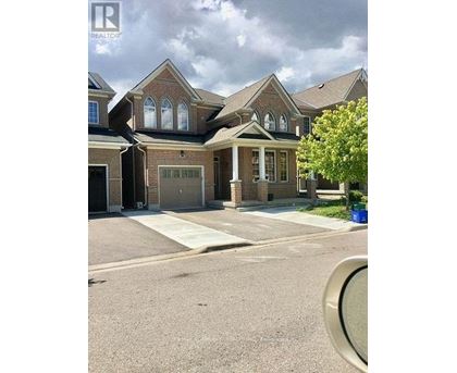 A large house with a brick facade and a large front yard.
