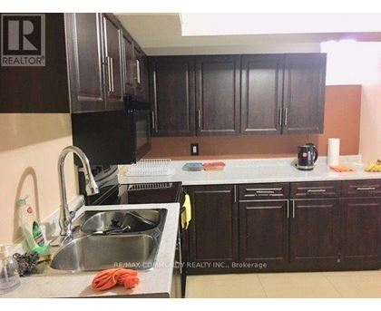 A kitchen with dark brown cabinets and a sink.