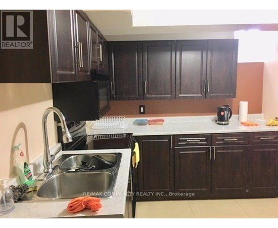 A kitchen with dark brown cabinets and a sink.