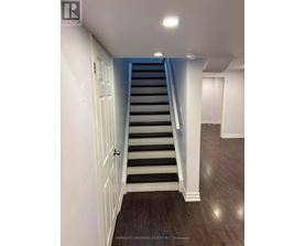 A staircase with a white door on the left and a light on the ceiling.