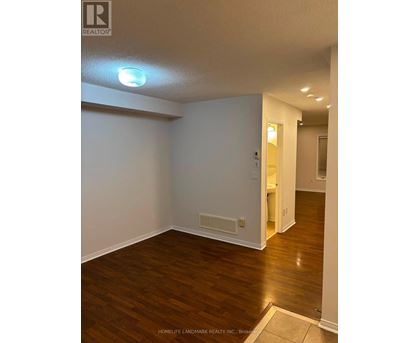 A room with wooden flooring and white walls.