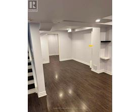 A room with wooden flooring and white walls.