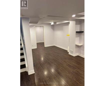 A room with wooden flooring and white walls.
