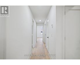 A long white hallway with a door on the right.