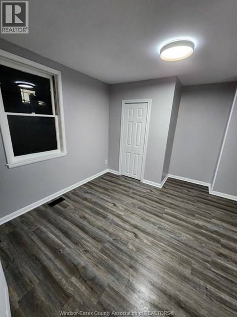 A room with a wooden floor and a white door.