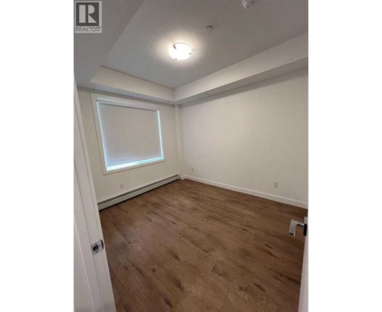 A room with wooden flooring and a window.