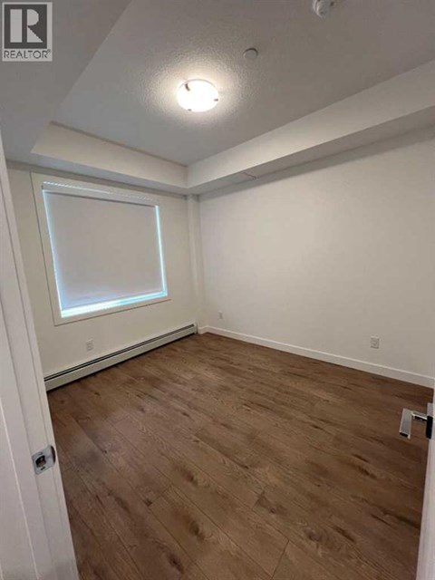 A room with wooden flooring and a window.