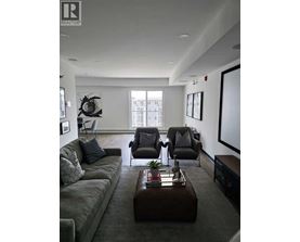 A living room with a grey couch, a brown coffee table, and a large window.