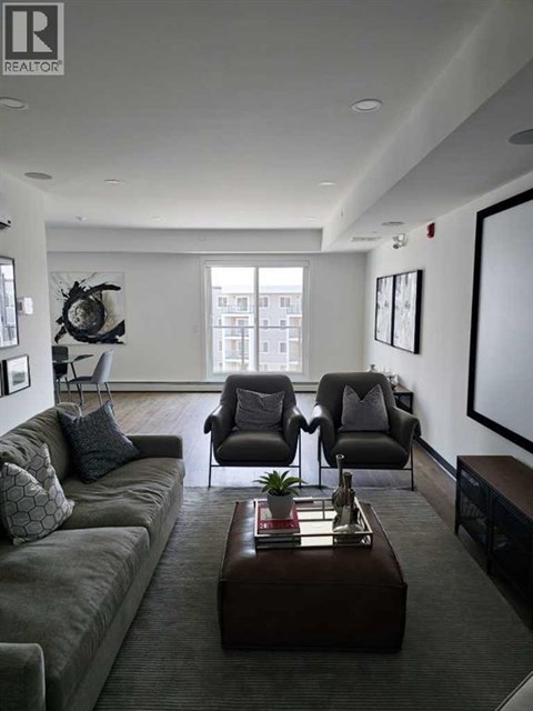 A living room with a grey couch, a brown coffee table, and a large window.