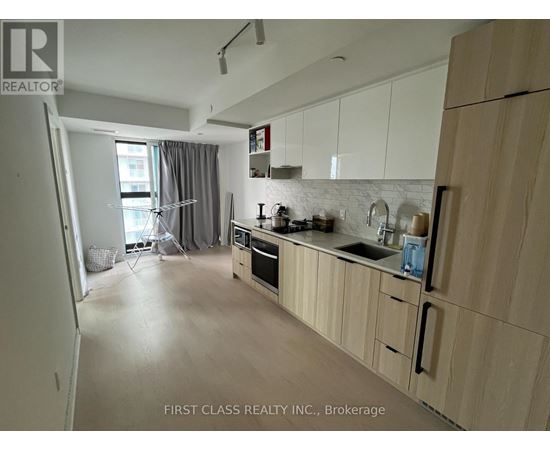 A kitchen with wooden cabinets and a white backsplash.