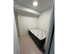 A bedroom with a bed and a wooden floor.