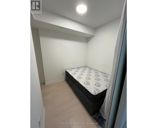 A bedroom with a bed and a wooden floor.
