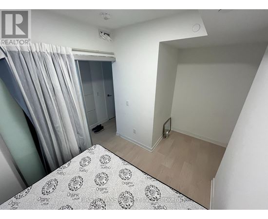 A bedroom with a bed and a window with curtains.