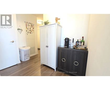 A white cabinet with a black door is in a room with a white wall.