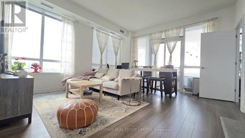 A living room with a couch, chairs, and a rug.