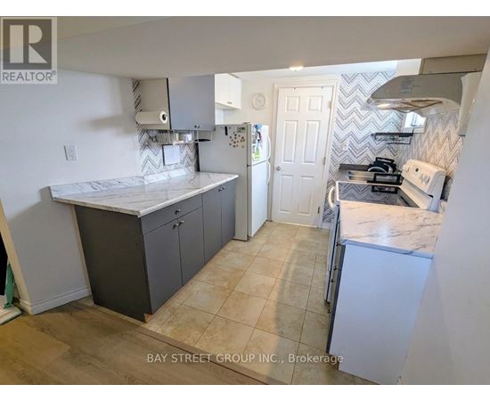 A kitchen with a marble countertop and a white fridge.