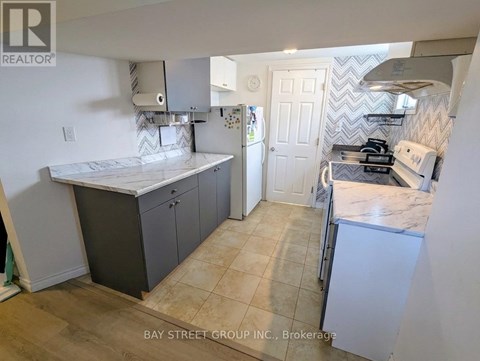 A kitchen with a marble countertop and a white fridge.