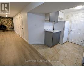 A kitchen area with a refrigerator, cabinets, and a countertop.