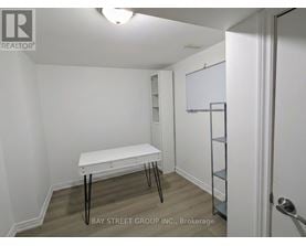 A white table with black legs in a white room.