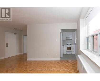 A spacious room with a kitchen area in the back.