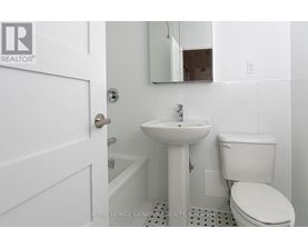 A white bathroom with a sink, toilet and mirror.