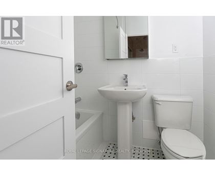 A white bathroom with a sink, toilet and mirror.