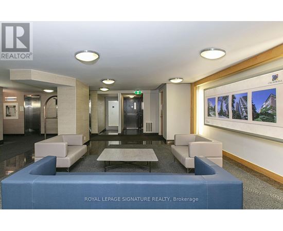 A modern office lobby with a reception desk and a wall of pictures.