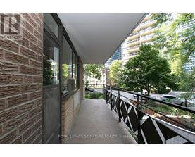 A balcony with a brick wall and a metal railing.
