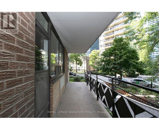 A balcony with a brick wall and a metal railing.