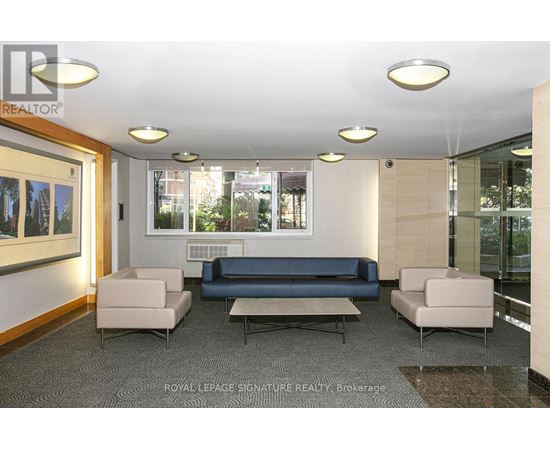 A well-lit waiting room with a couch, armchairs, and a coffee table.