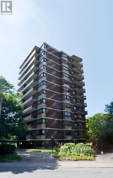 A tall residential building with balconies on the upper floors.