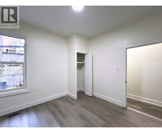 A room with a window and a door is available for rent.