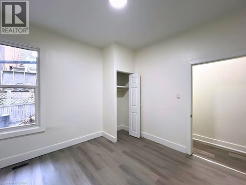 A room with a window and a door is available for rent.