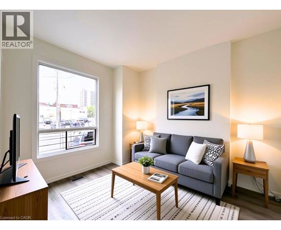 A living room with a grey couch, a wooden coffee table, and a painting on the wall.